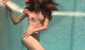 Молодая красотка плавает в бассейне абсолютно голенькая
